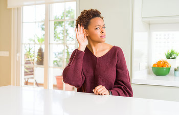 woman listens to noise sitting in the kitchen